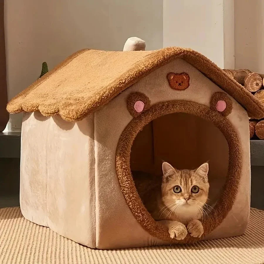Cat peeking out from a cozy pet house with a bear design on a neutral background