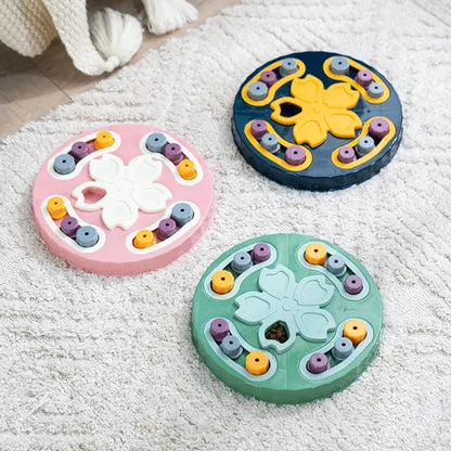 Three colorful circular toys with floral designs on a textured surface